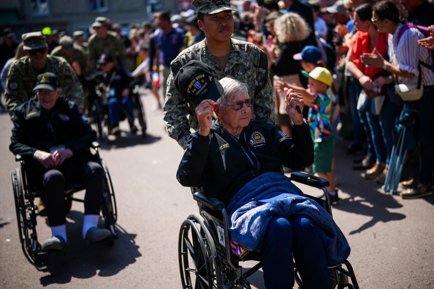 U.S. World War II veteran Marion Shipe gestures as he parades with other American Airlines veterans in Sainte-Mere-Eglise, Normandy, France, Wednesday, June 5, 2024.