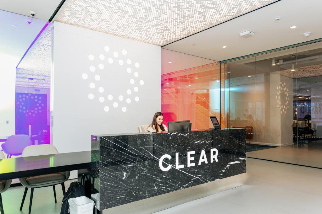 A woman sitting at a desk in front of a glass wall at CLEAR headquarters in Chelsea, Manhattan, photographed on May 22, 2024.