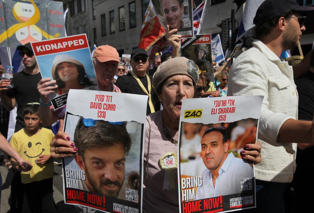 A protester holds up photos of two hostages still missing and unreturned during the demonstration. Thousands of people marched in Central London demanding the return of the Israeli hostages held by Hamas in Gaza, in London on June 2, 2024.