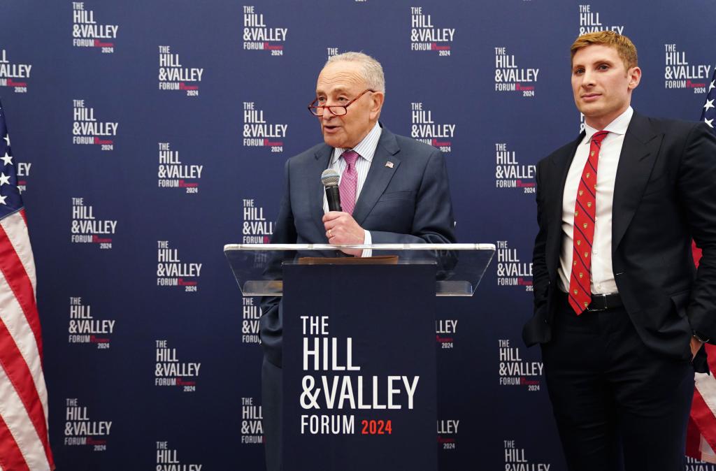 Majority Leader of the United States Senate, Chuck Schumer, and Jacob Helberg, Advisor to Palantir CEO, speaking at a podium during The Hill & Valley Forum Dinner at The Library of Congress, Washington, DC