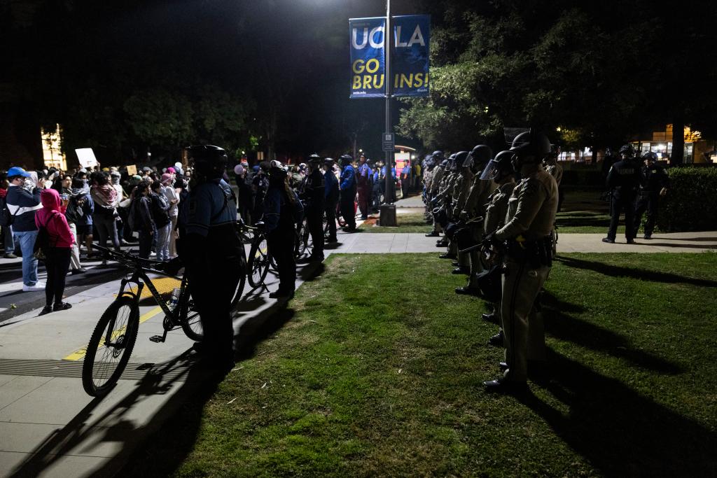 California Highway Patrol officers and private security guards stand in line facing pro-Palestinian protesters in front of the Dodd Hall in the University of California at Los Angeles (UCLA)