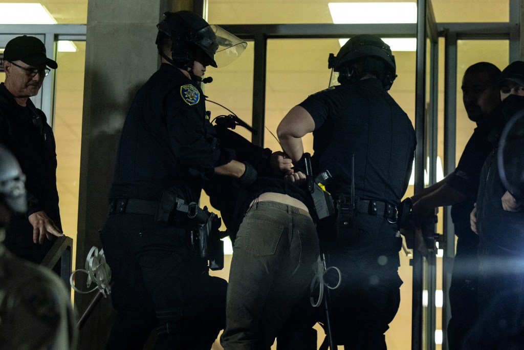 A pro-Palestinian demonstrator is taken into custody as University of California Police and California Highway Patrol officers face pro-Palestinian protesters outside Dodd Hall in the University of California at Los Angeles (UCLA) in Los Angeles, June 10, 2024.