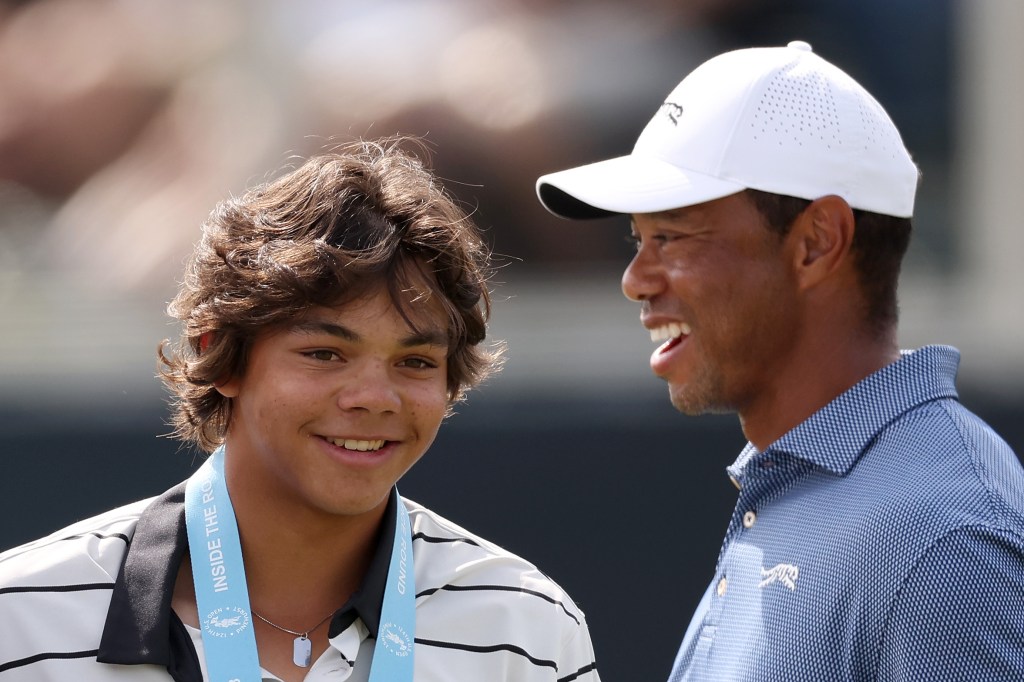 Tiger Woods (R) of the United States and son Charlie Woods (L) look on from the 18th green during a practice round prior to the U.S. Open at Pinehurst Resort on June 10, 2024 in Pinehurst, North Carolina.