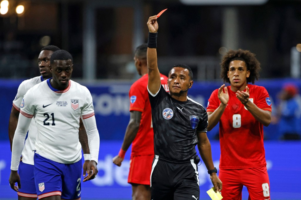 Referee Ivan Barton showing a red card to USA's forward Tim Weah during a 2024 Copa America football match between Panama and USA at Mercedes Benz Stadium