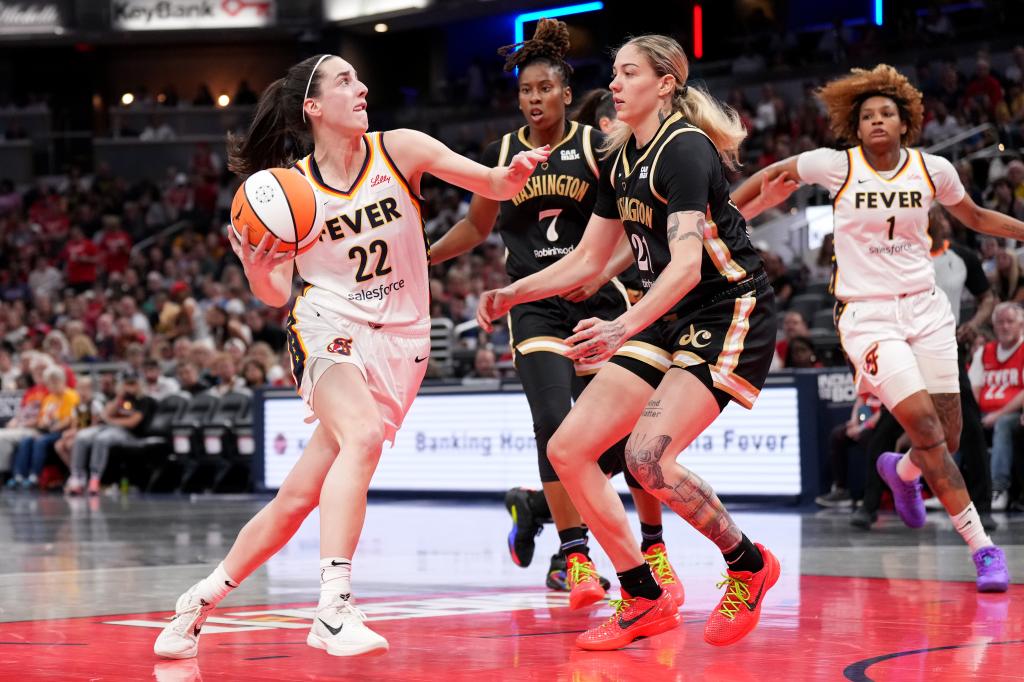 Caitlin Clark #22 of the Indiana Fever drives to the basket against Ariel Atkins #7 and Emily Engstler #21 of the Washington Mystics during the first half of a game at Gainbridge Fieldhouse on June 19, 2024 in Indianapolis, Indiana.  