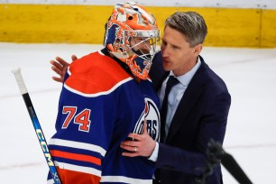 Oilers coach Kris Knoblauch speaks with goalie Stuart Skinner.