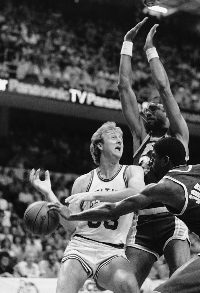 Magic Johnson of the Los Angeles Lakers knocks the ball from Larry Bird of the Boston Celtics during the 1984 NBA championship game, with Kareem Abdul-Jabbar in the background.