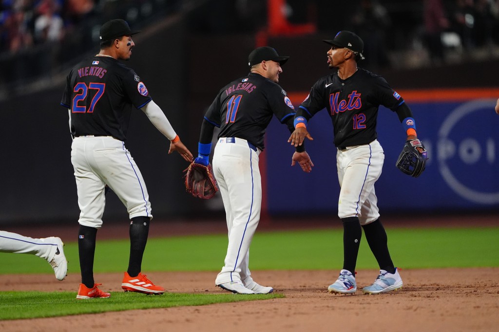 New York Mets players Mark Vientos, Jose Iglesias, and Francisco Lindor celebrating their victory on the field against the Arizona Diamondbacks at Citi Field