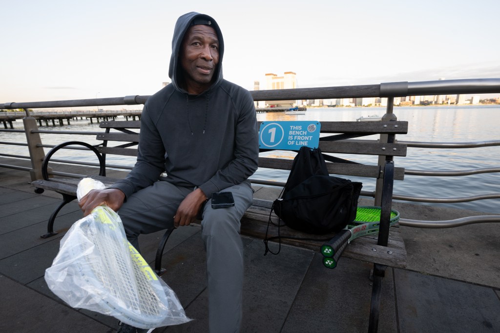 Instructor Scotty Spence sitting on a bench at Hudson River Park tennis courts, securing a spot for second round of court openings