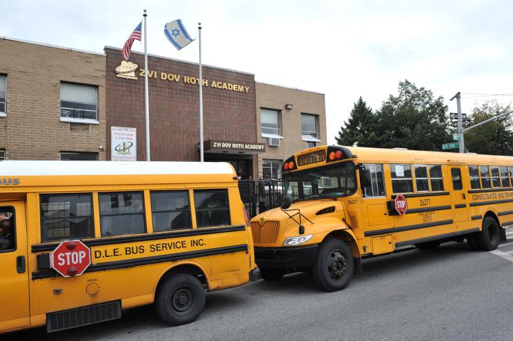 Two yellow buses parked in front of the Hebrew Language Academy charter school at 3300 Kings Highway in Midwood, Brooklyn.