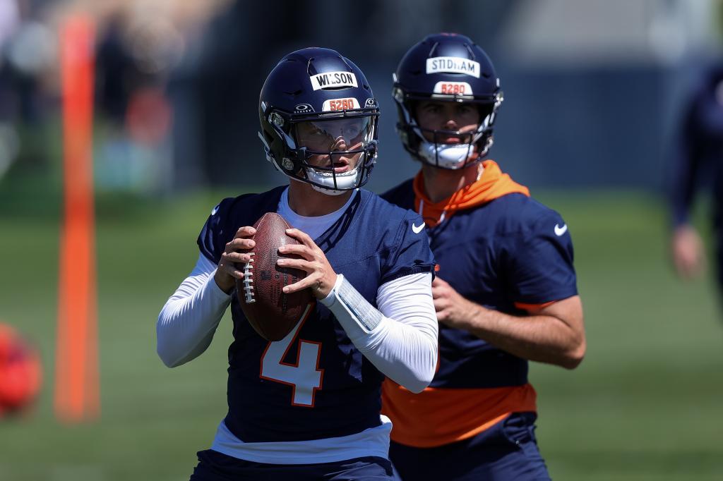 Zach Wilson (4) throws at Broncos practice alongside Jarrett Stidham on May 23, 2024.