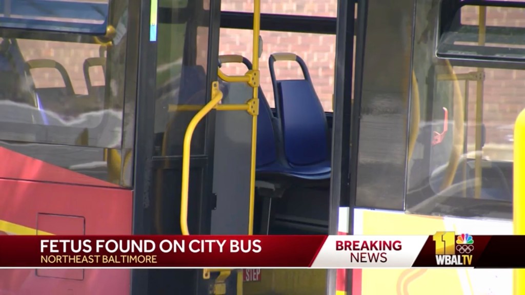 An empty MTA bus with blue seats at the 2500 block of Kirk Avenue in Baltimore, site of a police investigation