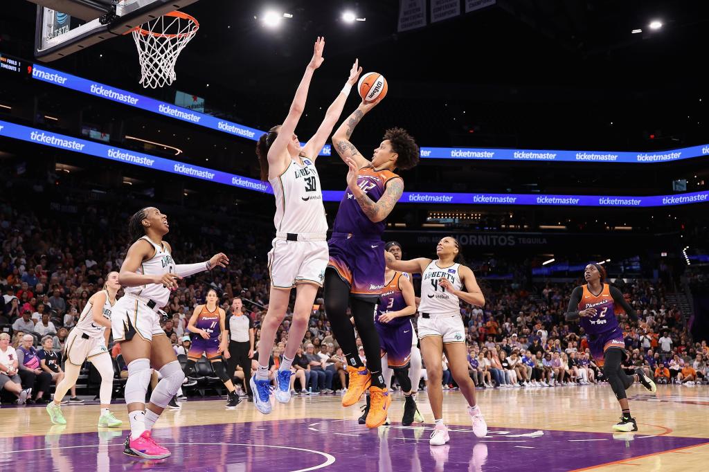 Brittney Griner of the Phoenix Mercury making a shot in a basketball game against Breanna Stewart of the New York Liberty