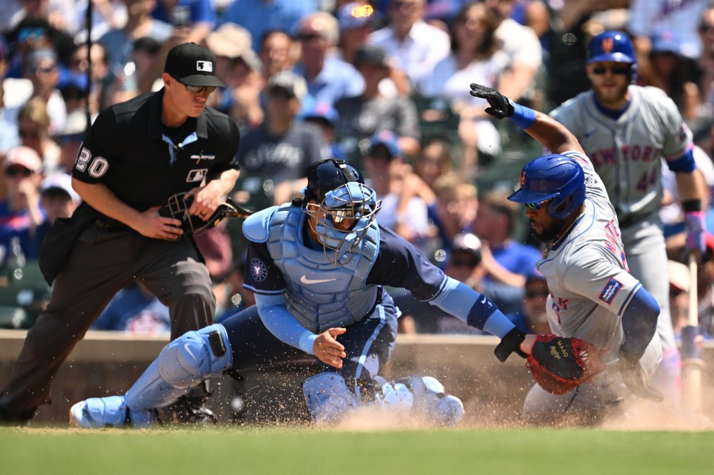 Starling Marte #6 of the New York Mets slides under the tag of Miguel Amaya #9 of the Chicago Cubs to score a run in the fourth inning at Wrigley Field on June 21, 2024 in Chicago, Illinois.