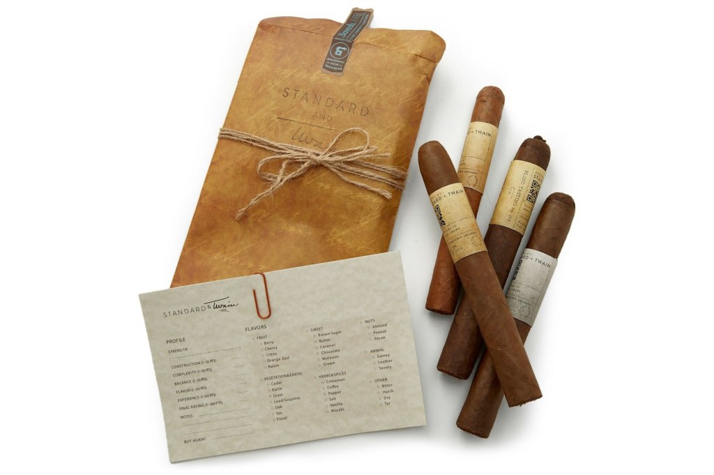 Cigars wrapped in brown paper next to a brown envelope