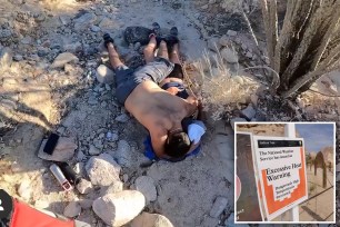 A man in shorts lays on top on a clothed woman in rocky terrain, protecting her from the elements. Inset: A sign warns visitors of excessive heat conditions in Joshua Tree National Park.