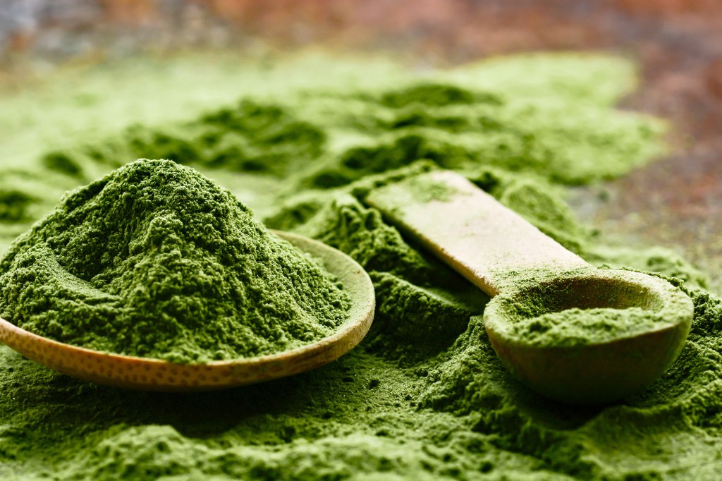 A spoon and a bowl of green detox superfood powder, Matcha, known for its restorative powers