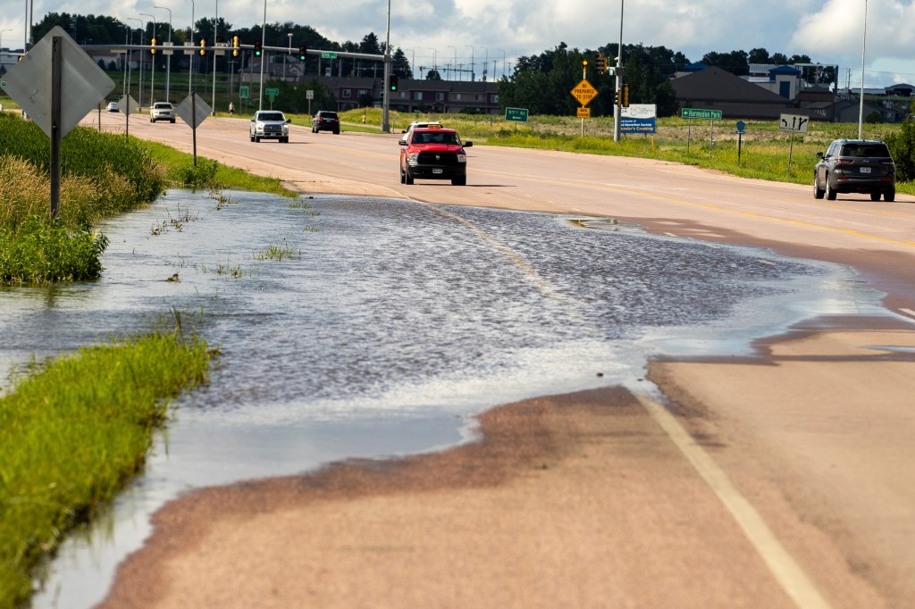South Dakota Department of Transportation truck blocking floodwaters on road due to heavy rainfall in Sioux Falls, South Dakota, on June 22, 2024