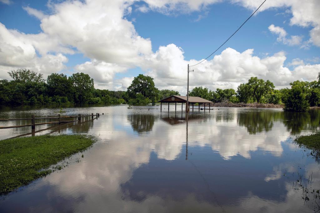 Flooded Rotary Park in Canton, South Dakota after heavy rainfall, showing a house submerged in water, captured on June 22, 2024