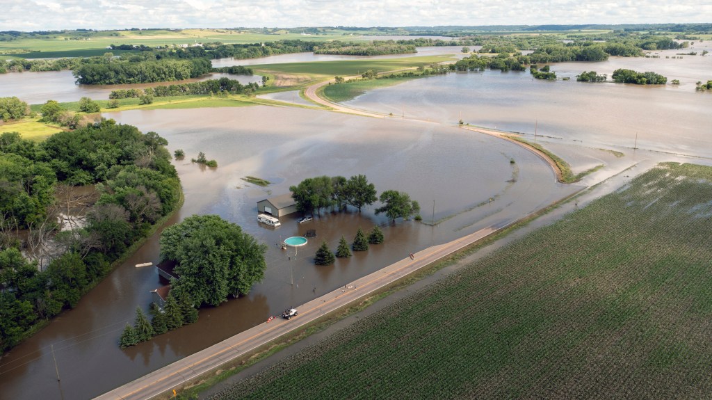 Flooded South Cedar Street with submerged trees and a house after days of heavy rain in Canton, South Dakota, June 22, 2024