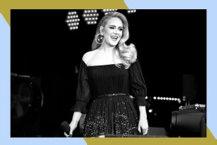 Adele smiles onstage with a microphone in hand.