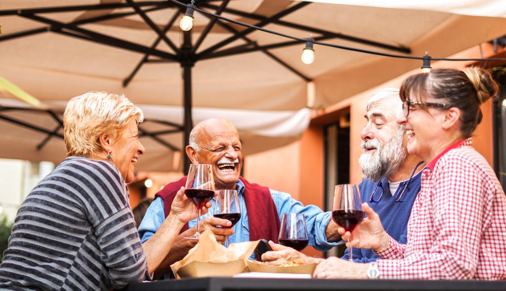 Group of old people eating and drinking outdoor - Doubble date with facemask on - Focusing glasses