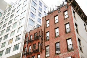 A general view of new modern high rise apartment building being built next to old fashioned apartment buildings on W38th Street in New York, NY on June 5, 2024.