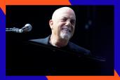 Billy Joel smiles from behind his piano.