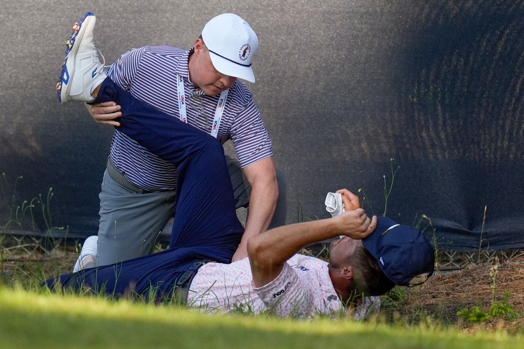 Bryson DeChambeau gets some treatment from a trainer on the 11th hole during the third round of the U.S. Open.