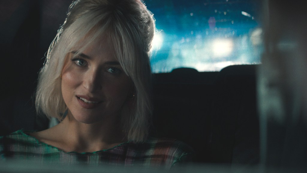 Dakota Johnson smiling in a car during a late-night drive, a still from "Daddio." 