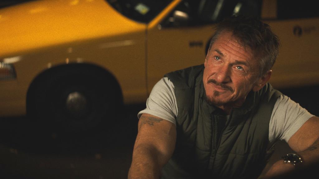 Sean Penn looks up with a yellow cab behind him in a "Daddio" still. 