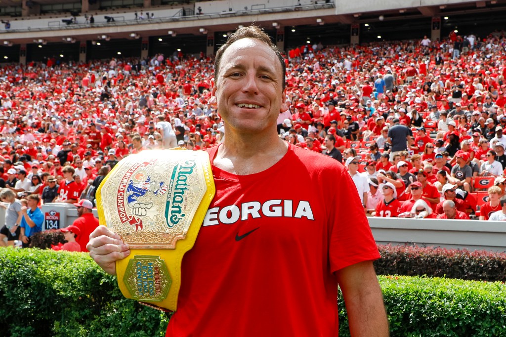 Competitive eater Joey Chestnut poses with his mustard yellow championship belt during a game between the Georgia Bulldogs and the Ball State Cardinals at Sanford Stadium on September 9, 2023 in Athens, Georgia. 