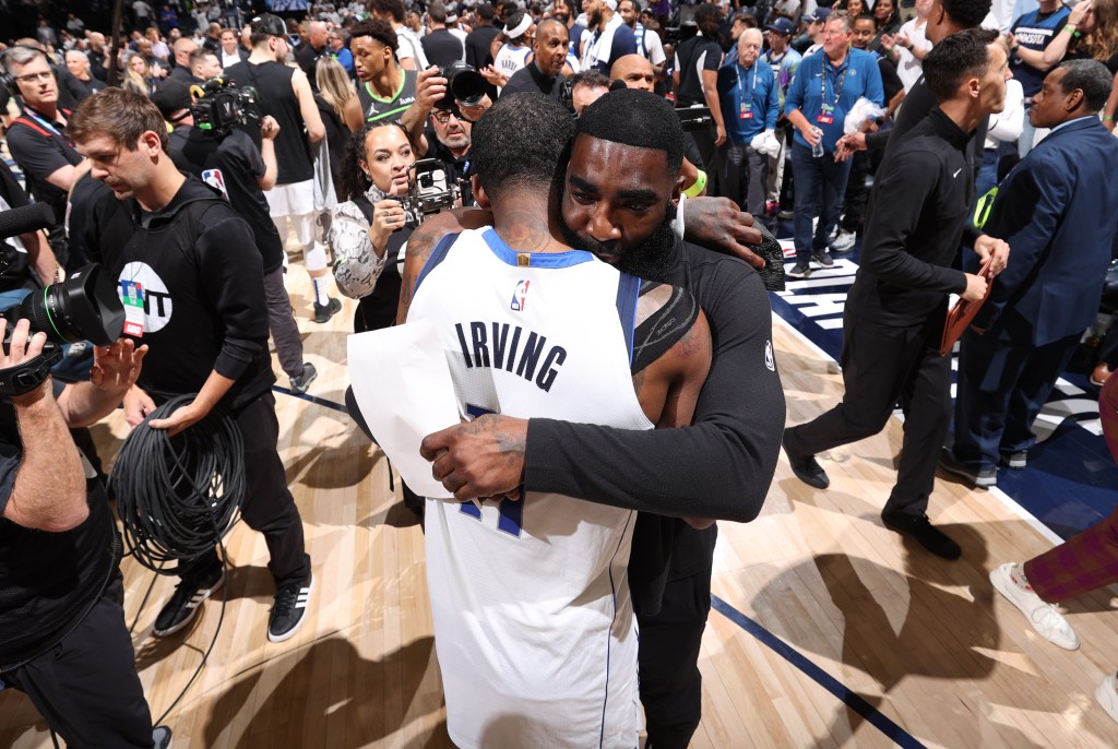 Mavericks assistant God Shammgod hugs Kyrie Irving after Dallas' Game 3 win over the Timberwolves in the Western Conference Finals.