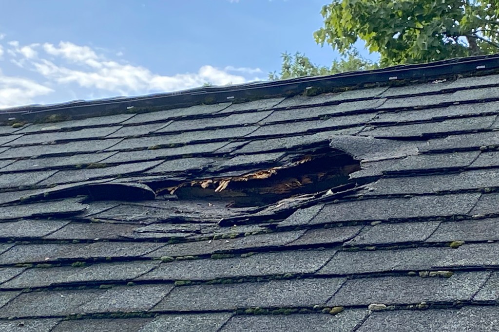 Jeff Ilg shows damage to his home, in Shirley, Mass., where a chunk of ice landed on the roof late Sunday, Aug. 13, 2023.