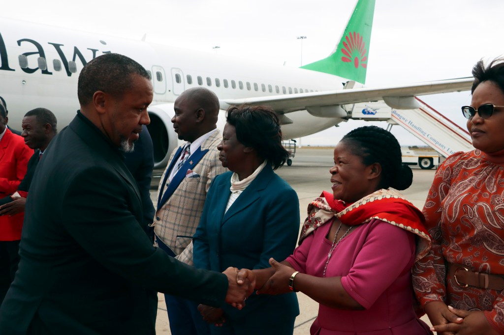 Malawi Vice President Saulos Chilima, left, greets government officials upon his return from South Korea in Lillongwe, Sunday, June 9, 2024.