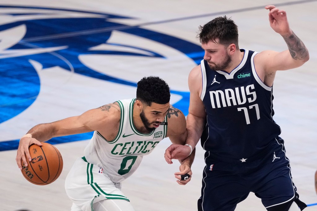 Jayson Tatum of the Boston Celtics driving to the basket against Luka Doncic of the Dallas Mavericks during the NBA finals game