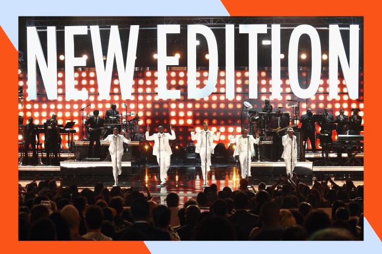 The fivesome performs together onstage in front of a sign with the band's name.