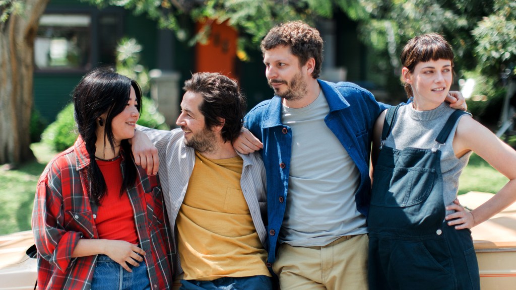 Maya Erskine, Michael Angarano, Michael Cera and Kristen Stewart stand with arms around each other in a still from "Sacramento."