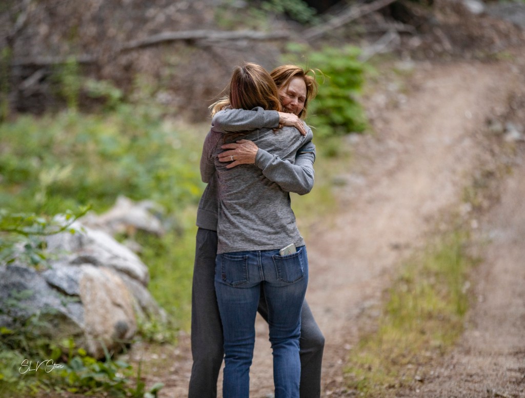 People embrace after the hiker was found.