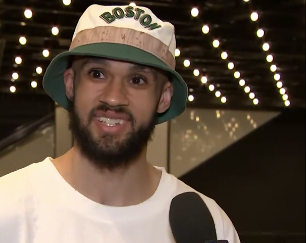 Celtics guard Derrick White shows off his repaired front tooth before the team's championship parade.