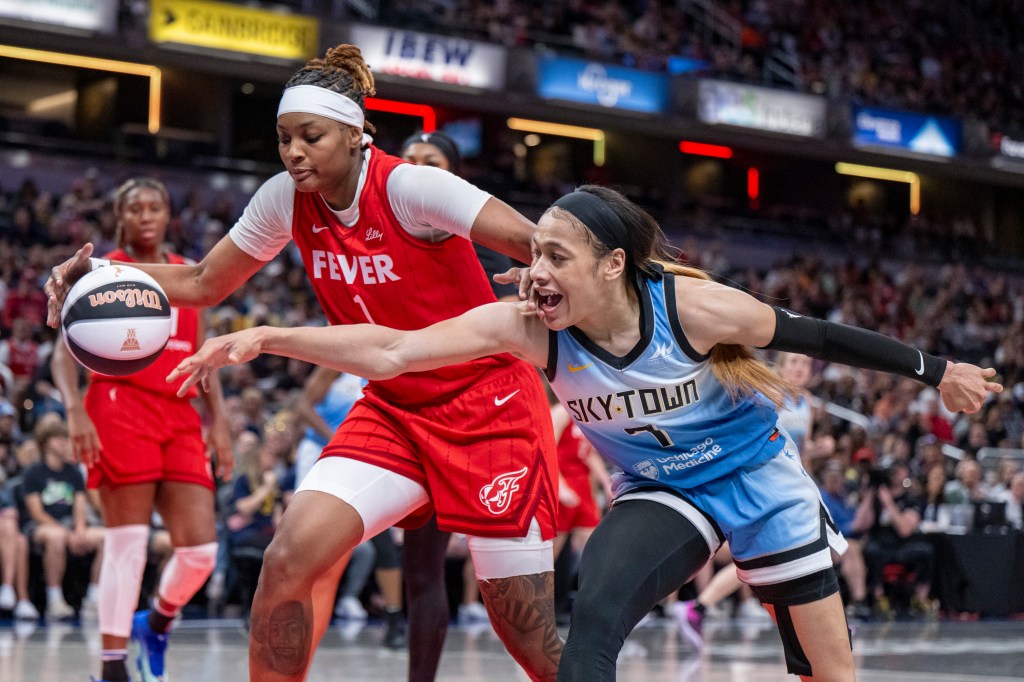 Indiana Fever forward NaLyssa Smith and Chicago Sky guard Chennedy Carter reaching for the ball during a WNBA basketball game in Indianapolis