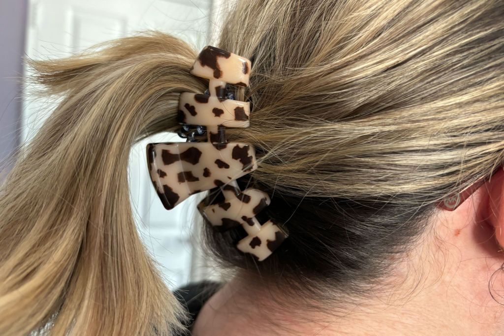 The back of a woman's head with a claw clip keeping her hair back. 