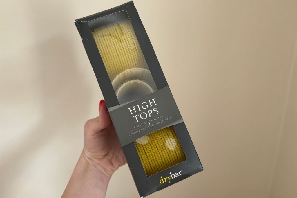 A hand holding a box of DryBar rollers.