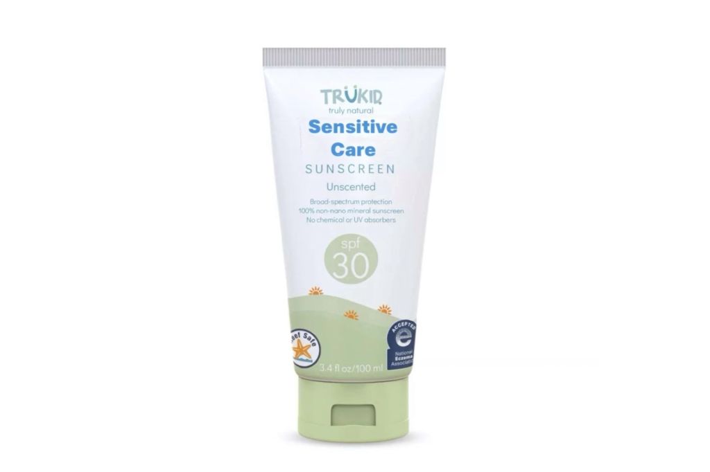 A tube of mineral sunscreen for kids in a white and green bottle