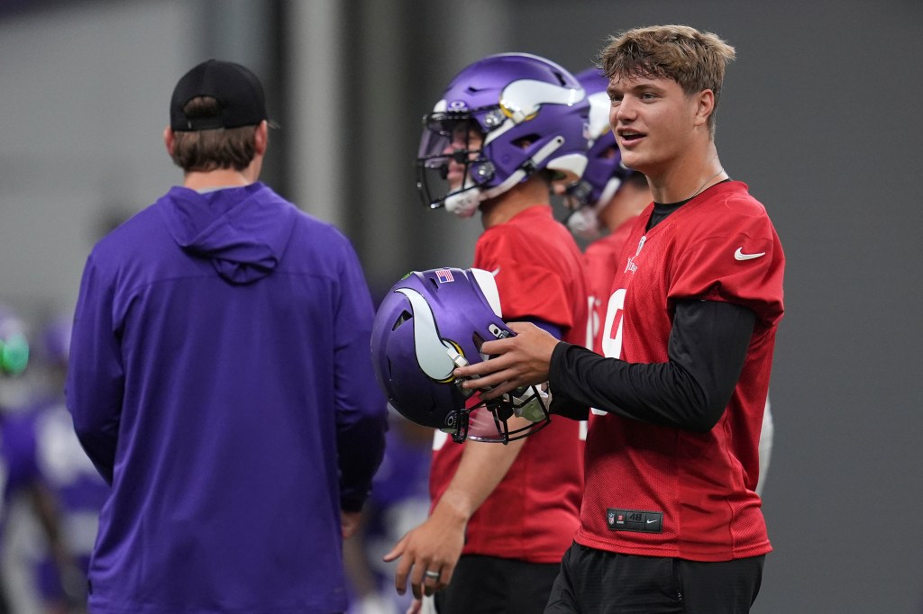 Minnesota Vikings quarterback J.J. McCarthy, right, stands on the field during NFL football practice in Eagan, Minn., Tuesday, May 21, 2024.