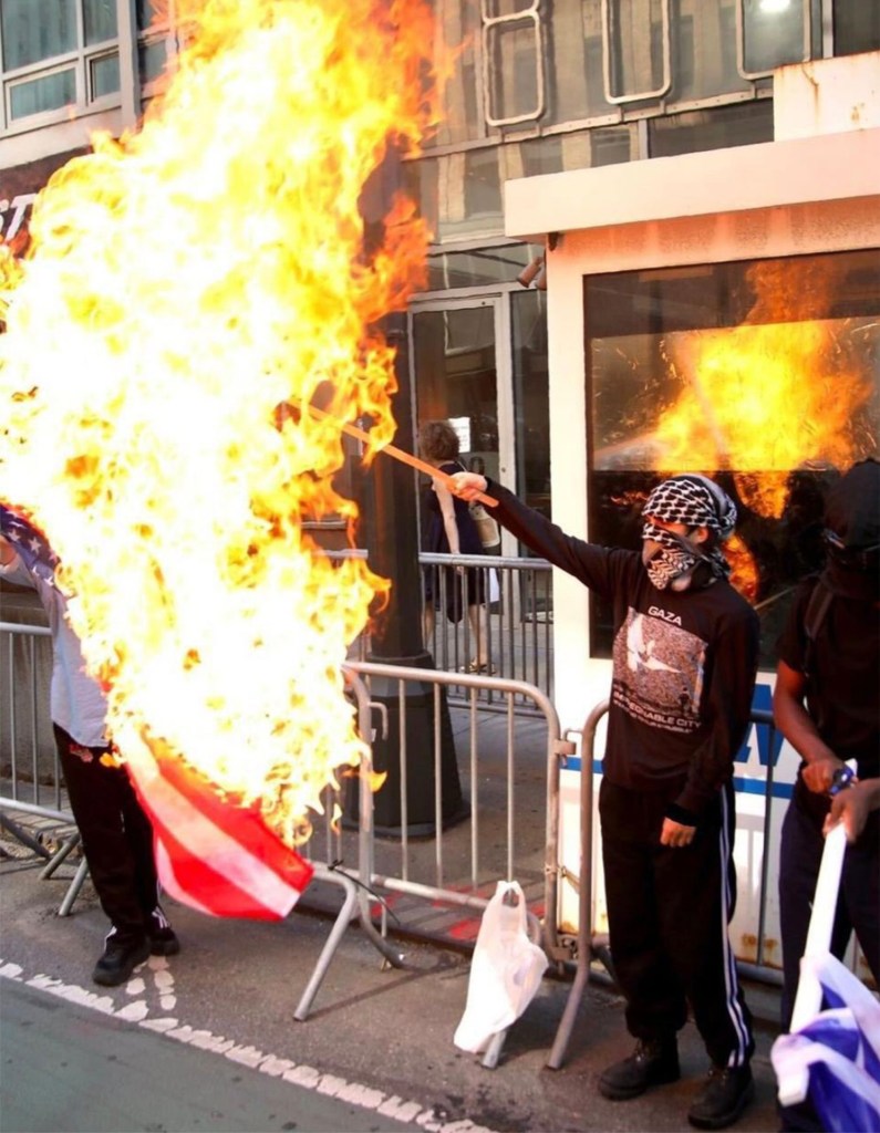 Pro-Palestinian demonstrators burning an American flag in front of the Israeli consulate in New York