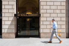 Worker walking pass a building at Wall Street.