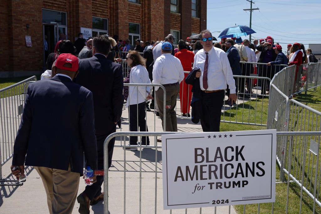 Audience members line up behind a "Black Americans for Trump" sign outside a campaign community roundtable with Republican presidential candidate and former U.S. President Donald Trump