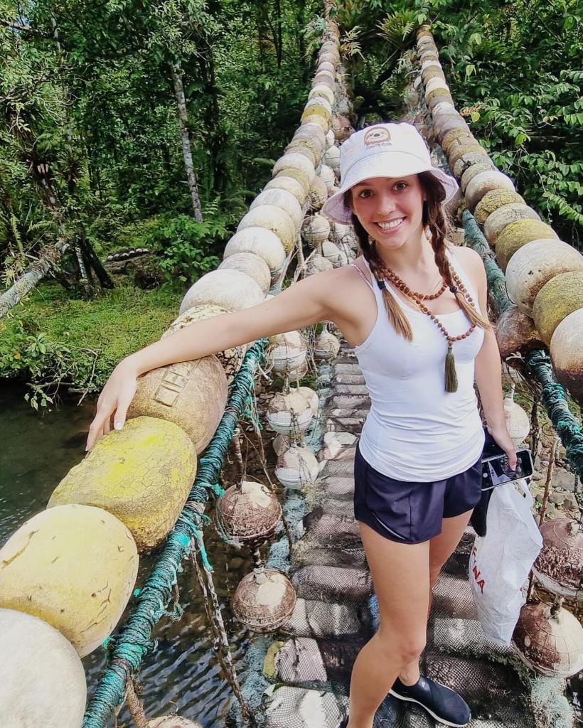 Jordon Hudson standing on a bridge surrounded by rocks, during her trip to Costa Rica