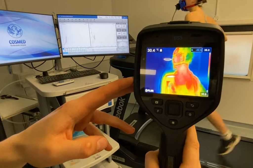 A person holding a camera performing a body scan for a study on how bra size impacts sweat production, particularly during hot conditions.
